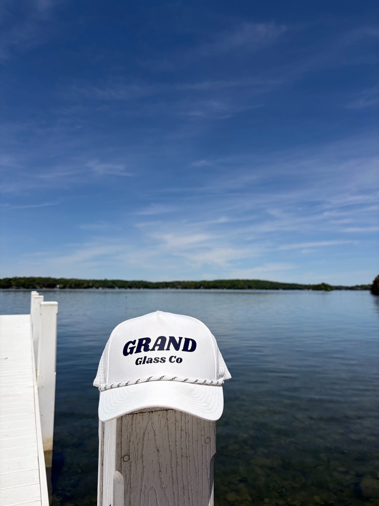 Grand Glass Co hat on a dock post overlooking a lake